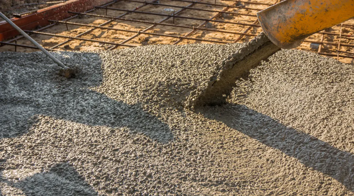 Concreto usinado sendo lançado sobre a malha de aço de uma laje