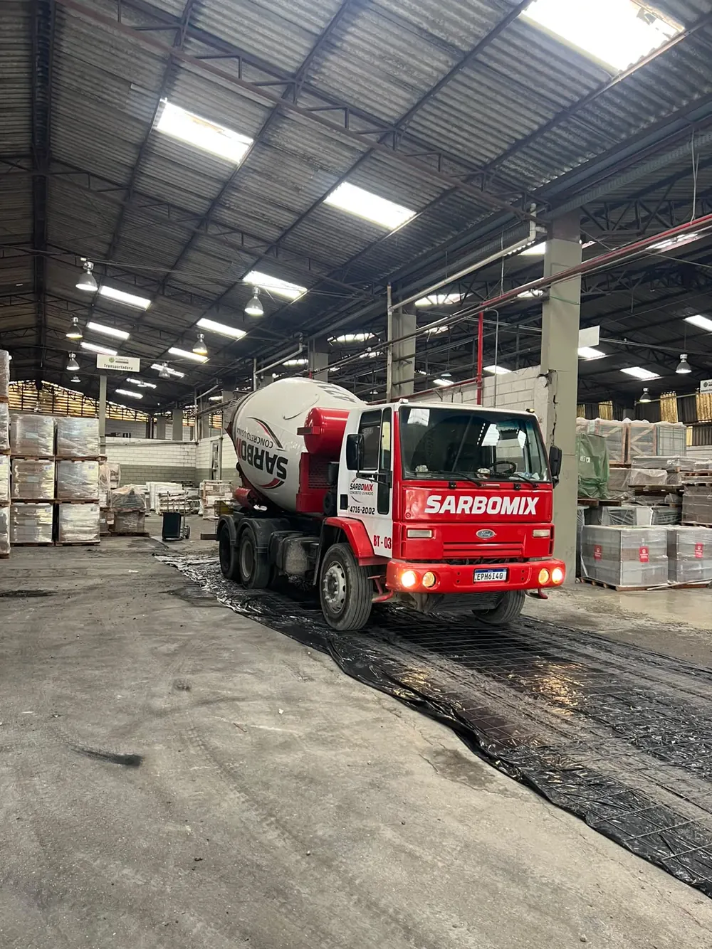Betoneira SarboMix entregando concreto dentro de um galpão logístico