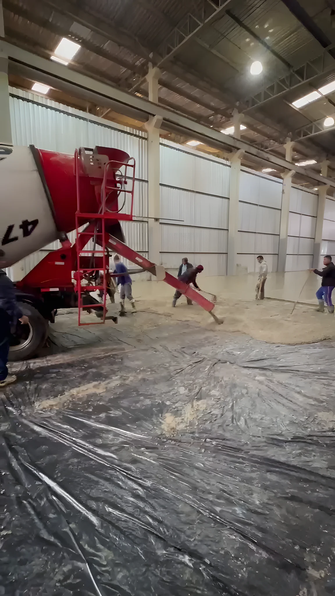 Equipe espalhando e nivelando o concreto recém-lançado